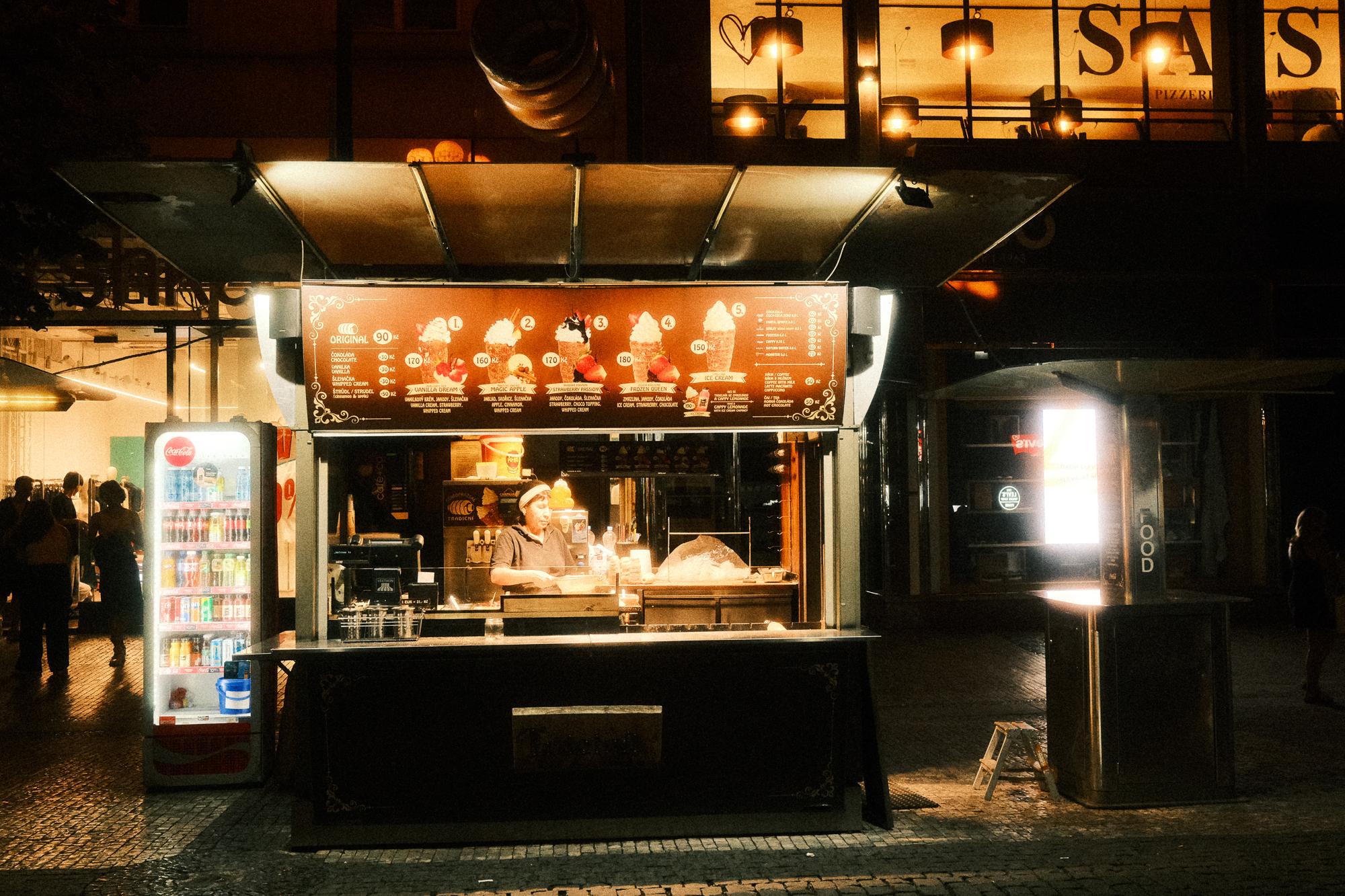 Nočná ulica so stánkom s rýchleho občerstvenia.