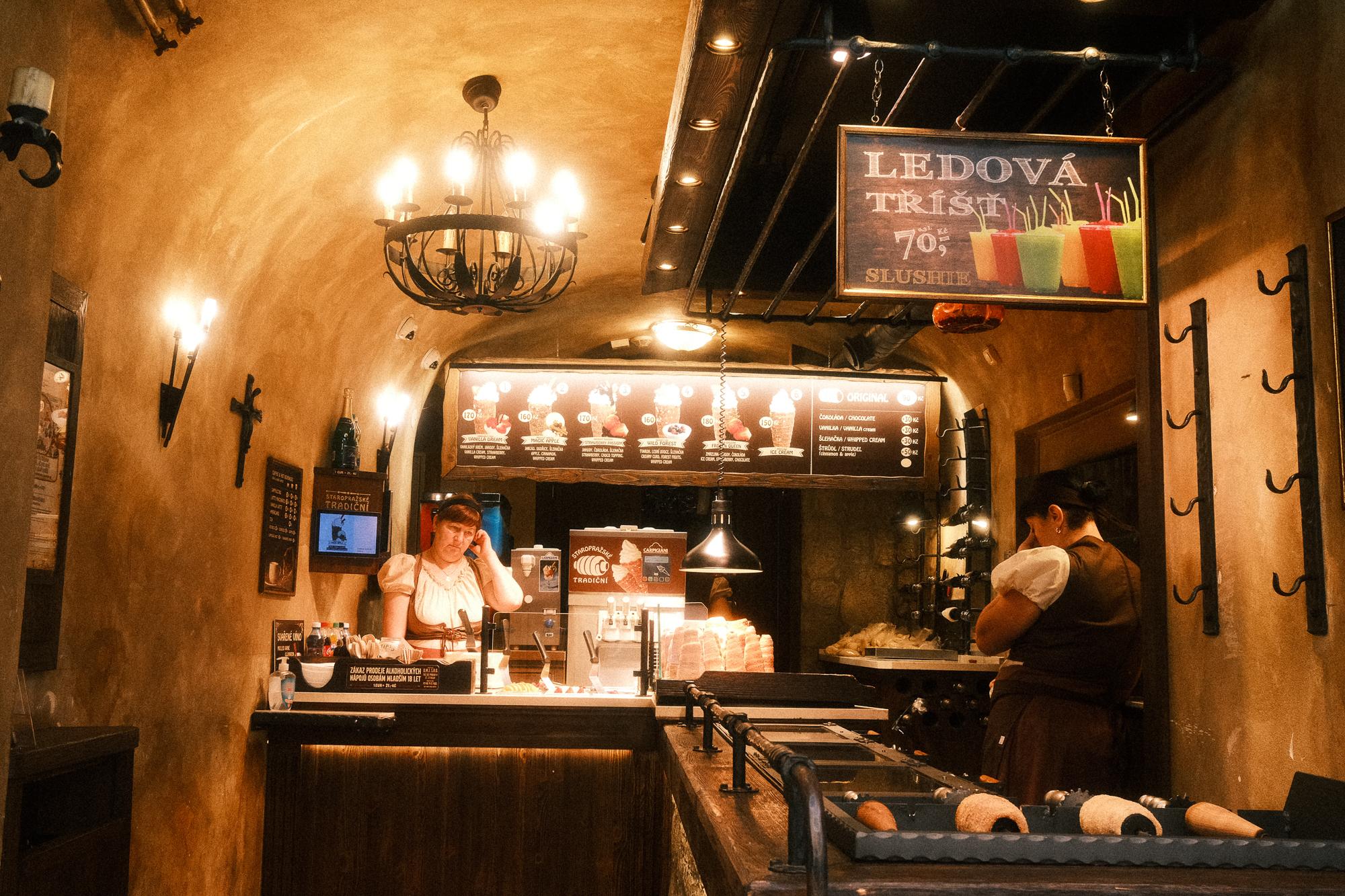 Interiér obchodu so sladkosťami pre turistov s unavenými pracovníčkami v tradičných odevoch.