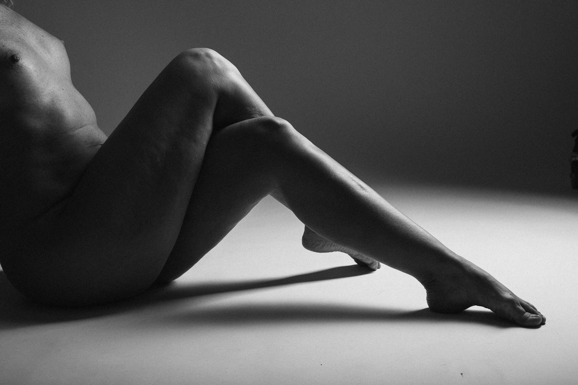 Black and white artistic nude photograph featuring elegantly crossed legs.  Shot at Studio Pezinok.