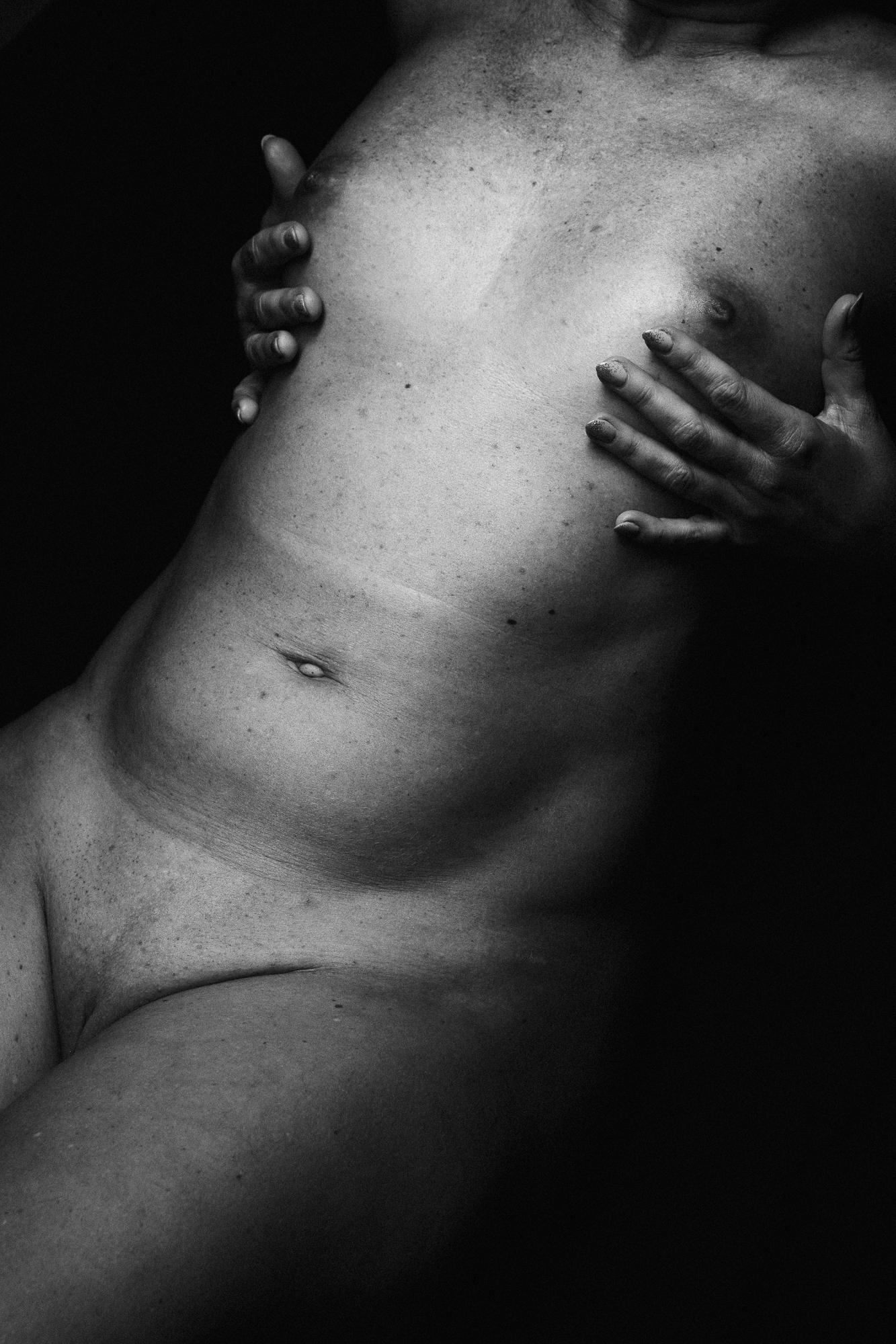 Black and white artistic nude photograph capturing the details of the female body, emphasizing delicate lines and natural beauty, Studio Pezinok.