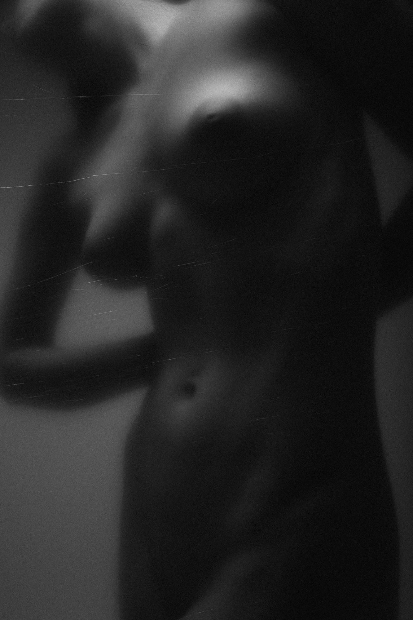 Black and white artistic nude photograph capturing the gentle lines and dynamics of the female form, Studio Pezinok.