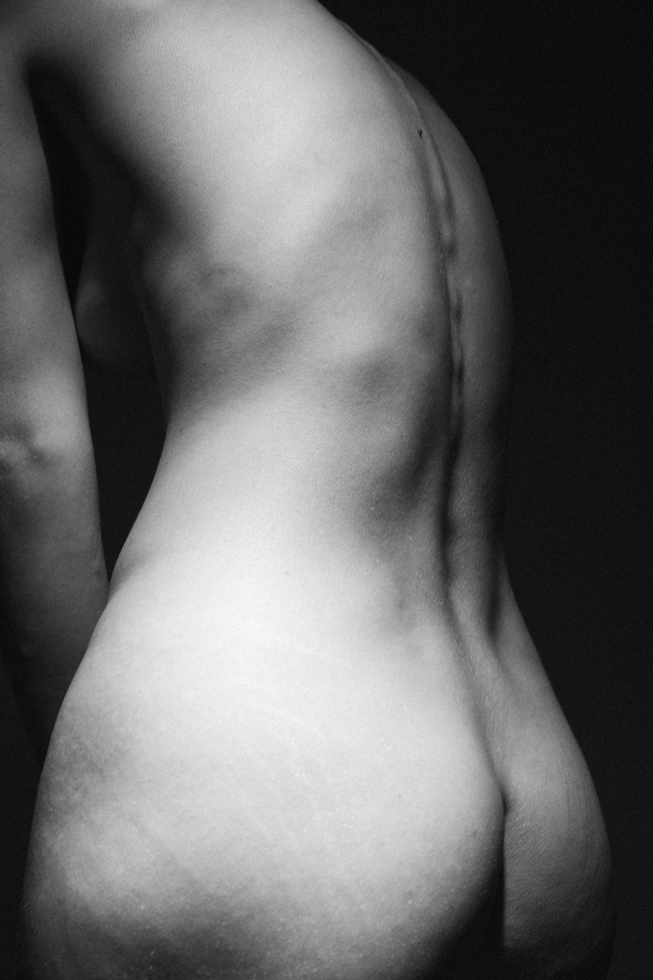 Black and white artistic nude photograph showing a detailed view of human body curves under studio lighting. Studio Pezinok.
